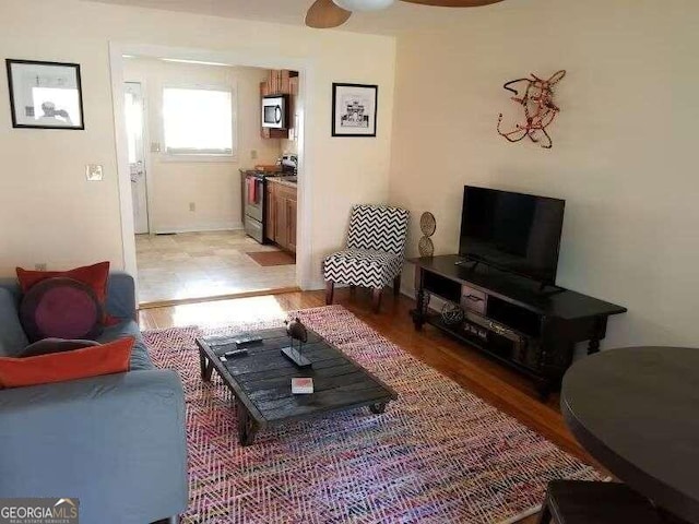 living room featuring ceiling fan and light hardwood / wood-style floors