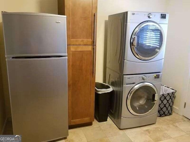 washroom with cabinets and stacked washer and clothes dryer