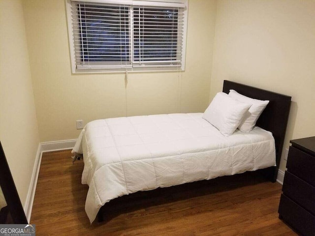 bedroom with dark wood-type flooring