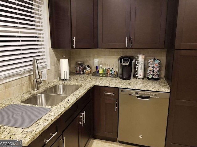 kitchen featuring sink, light stone countertops, decorative backsplash, stainless steel dishwasher, and dark brown cabinetry