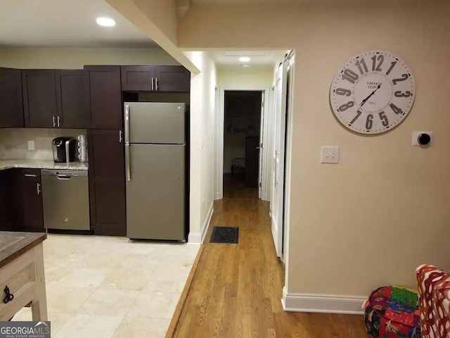 kitchen featuring stainless steel appliances, light wood-type flooring, and dark brown cabinets