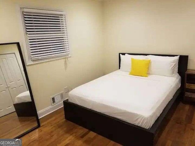 bedroom with dark hardwood / wood-style flooring