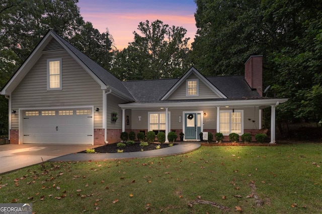 view of front of property with a porch, a garage, and a lawn