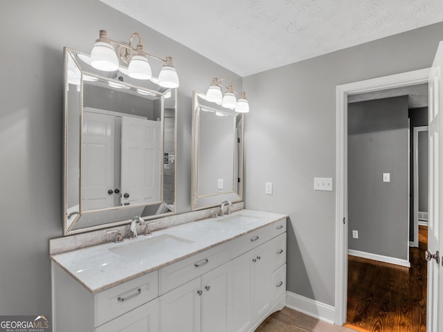 bathroom featuring hardwood / wood-style floors, vanity, and a textured ceiling