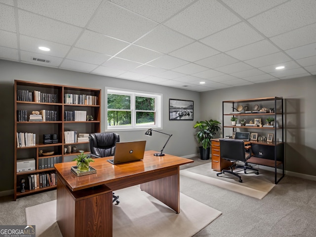 carpeted office space featuring a paneled ceiling