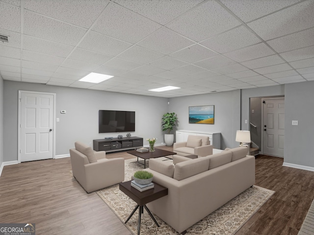 living room featuring a paneled ceiling and hardwood / wood-style flooring