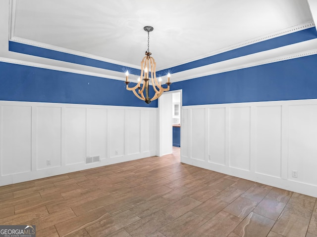 unfurnished dining area with ornamental molding and an inviting chandelier