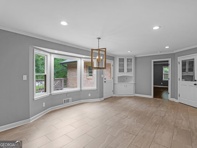 interior space with a notable chandelier, plenty of natural light, and crown molding