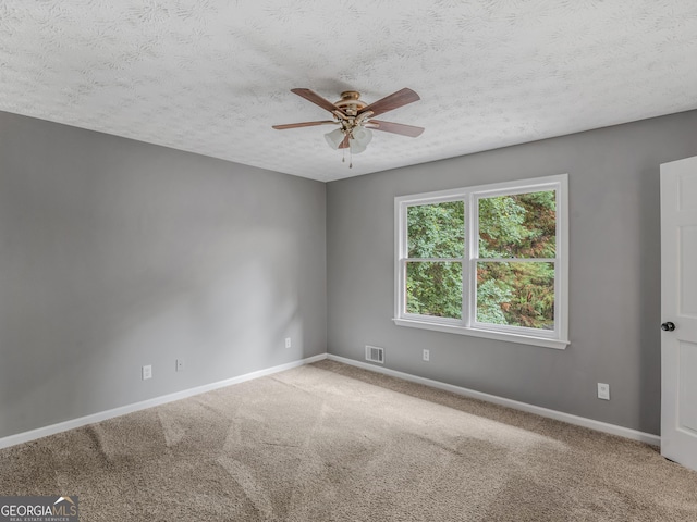 carpeted empty room featuring ceiling fan and a textured ceiling