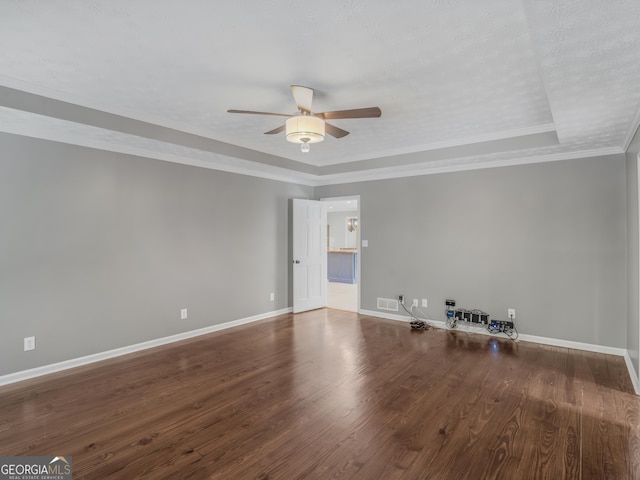 spare room featuring ornamental molding, a textured ceiling, a raised ceiling, ceiling fan, and hardwood / wood-style flooring