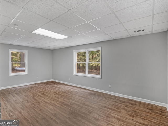 spare room featuring hardwood / wood-style floors, a paneled ceiling, and a wealth of natural light