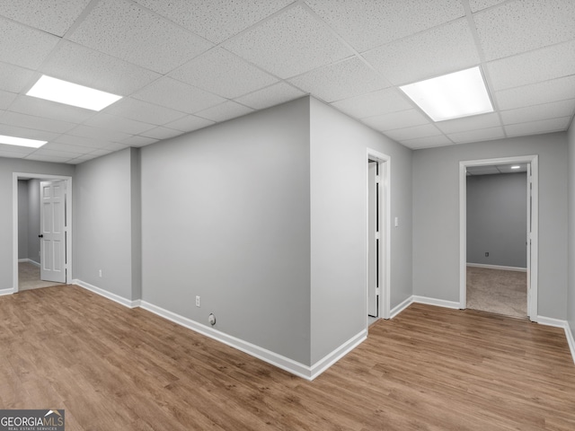 basement with a drop ceiling and light wood-type flooring