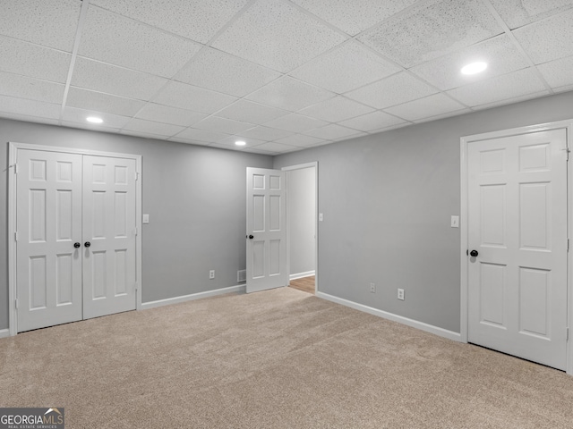 basement with light carpet and a drop ceiling