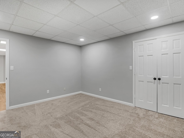 interior space featuring carpet flooring and a drop ceiling