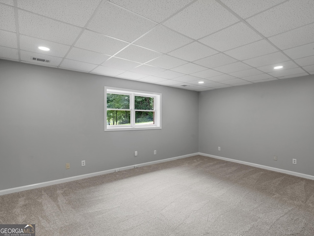 carpeted spare room with a paneled ceiling