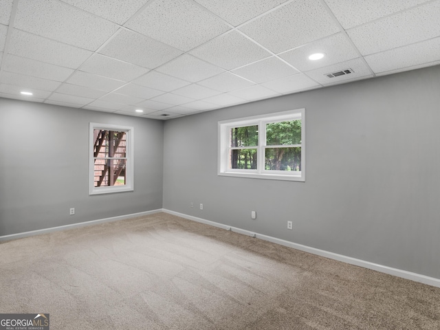 spare room featuring carpet and a paneled ceiling