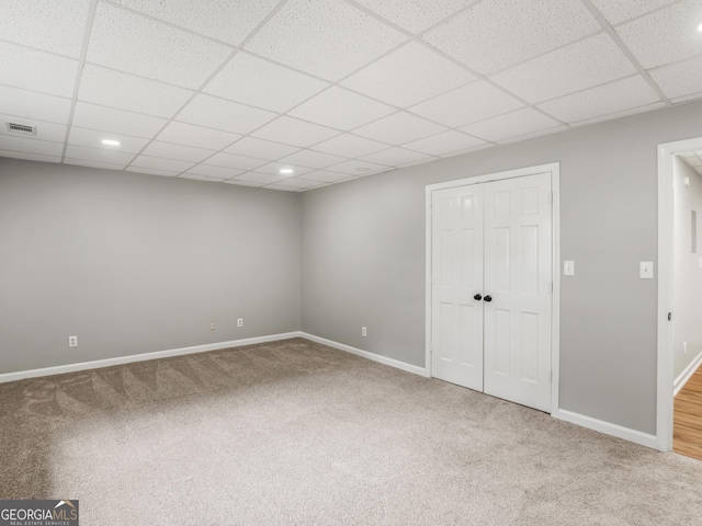 interior space featuring carpet floors, a closet, and a paneled ceiling