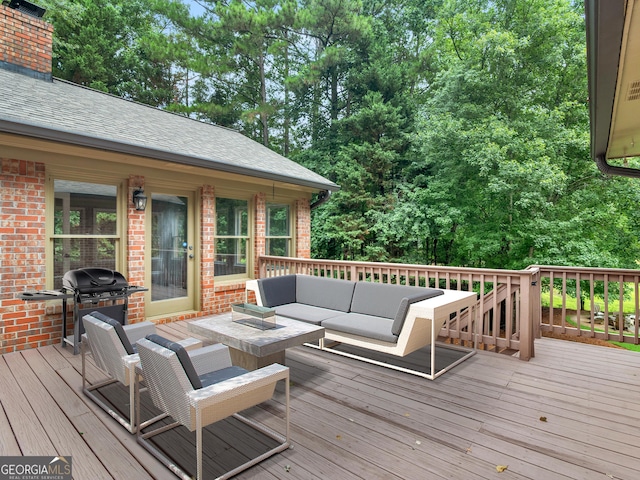 wooden terrace featuring grilling area and an outdoor living space with a fire pit