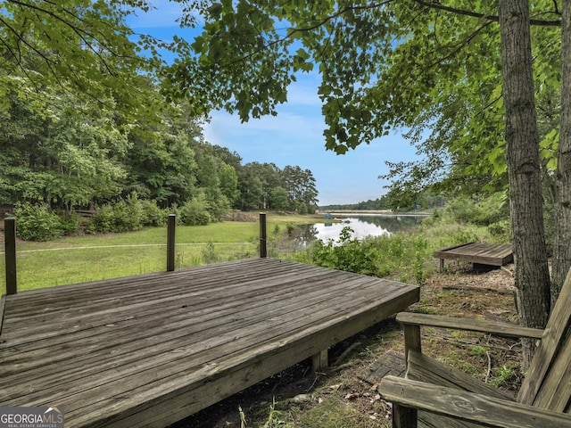 wooden deck with a lawn and a water view