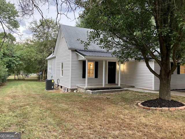 view of front of home with a porch, cooling unit, and a front lawn