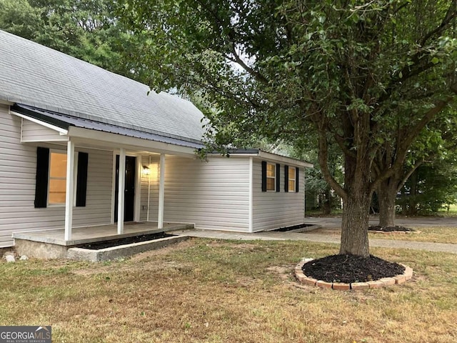 view of property exterior featuring a porch and a yard