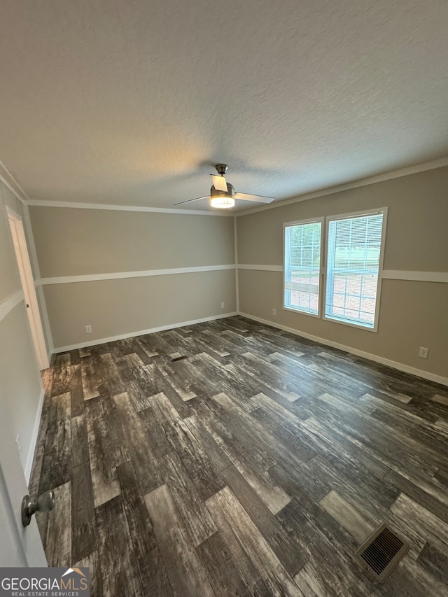 empty room featuring ceiling fan, dark hardwood / wood-style floors, crown molding, and a textured ceiling