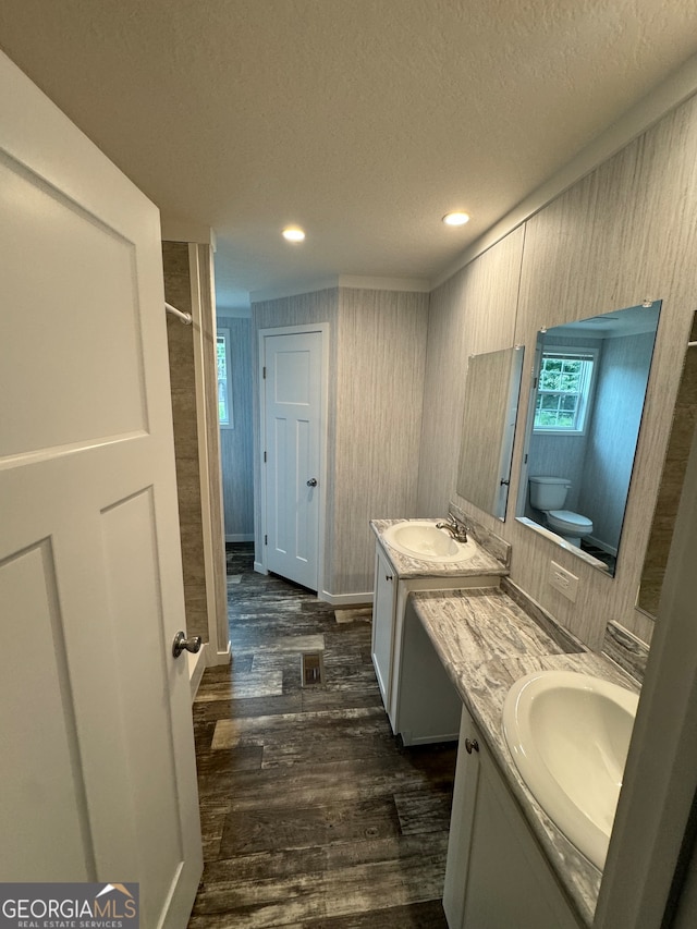 bathroom featuring hardwood / wood-style floors, toilet, a textured ceiling, and vanity