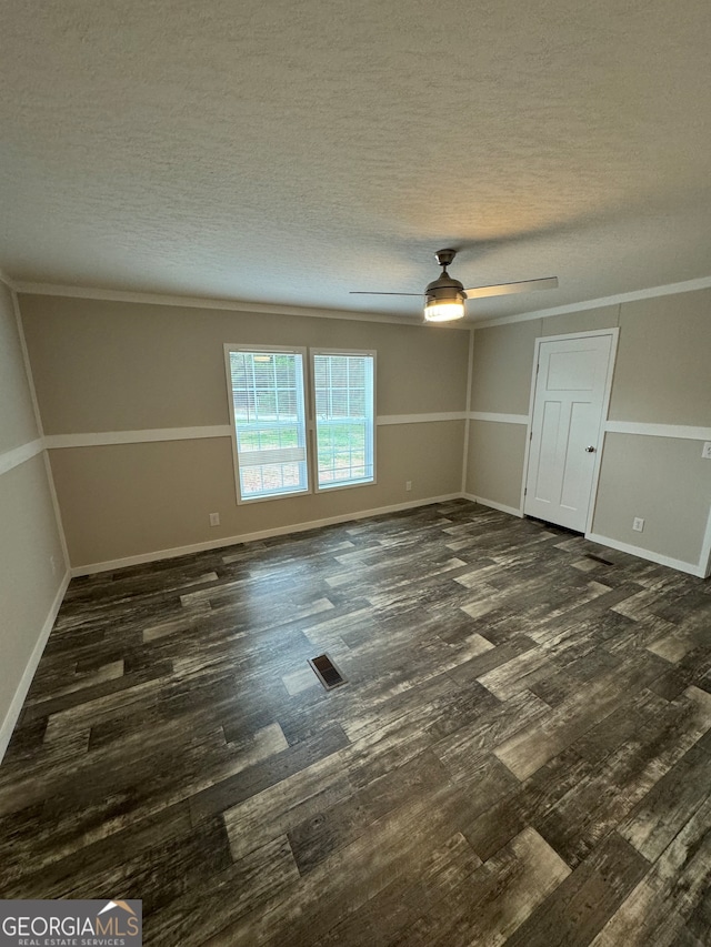 spare room with ornamental molding, dark wood-type flooring, a textured ceiling, and ceiling fan