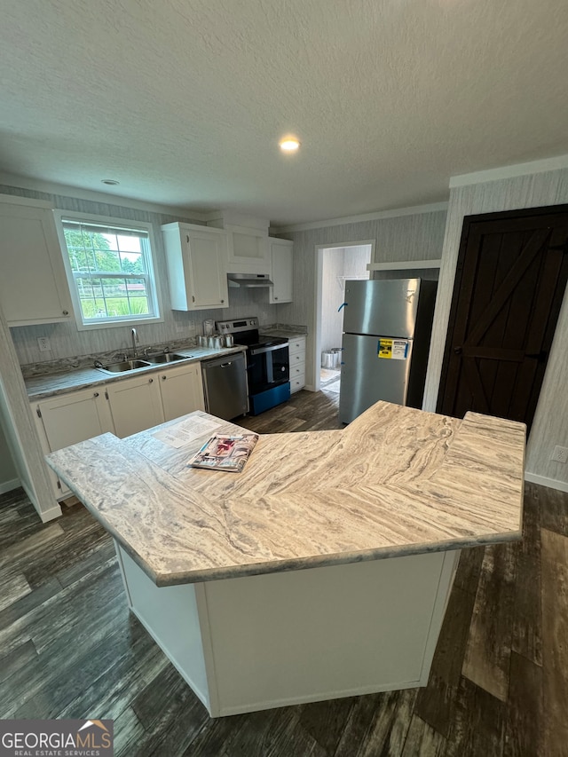 kitchen with white cabinets, a center island, stainless steel appliances, and sink