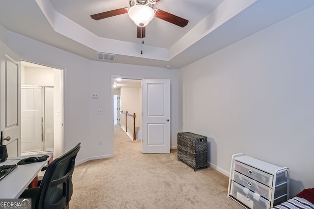 carpeted office with a raised ceiling and ceiling fan