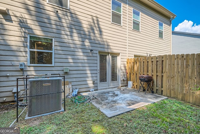 rear view of house with a patio area, a lawn, and central air condition unit