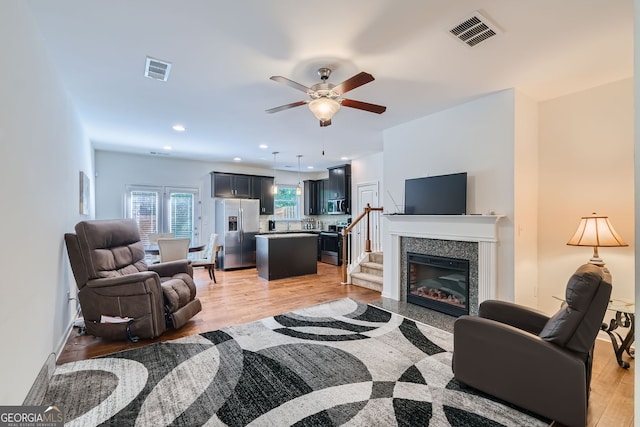 living room featuring light wood-type flooring and ceiling fan