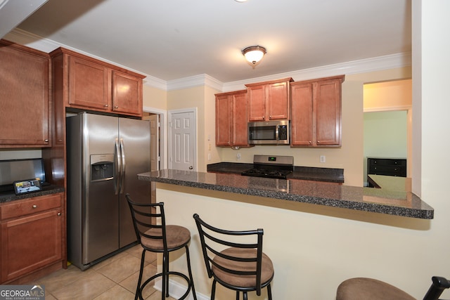 kitchen featuring kitchen peninsula, ornamental molding, a breakfast bar area, and appliances with stainless steel finishes