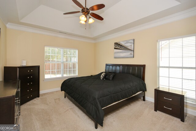 bedroom with ceiling fan, light colored carpet, crown molding, and multiple windows