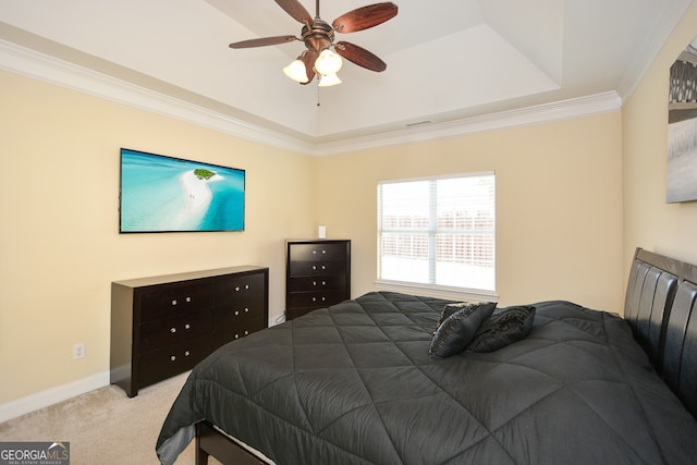 carpeted bedroom with ornamental molding, ceiling fan, and a tray ceiling