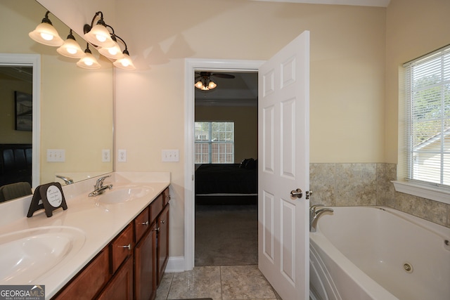 bathroom with tile patterned flooring, a tub, vanity, and ceiling fan