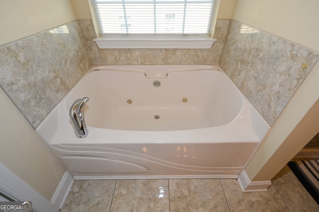 bathroom with tile patterned flooring and a washtub