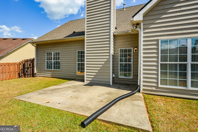 rear view of property with a yard and a patio