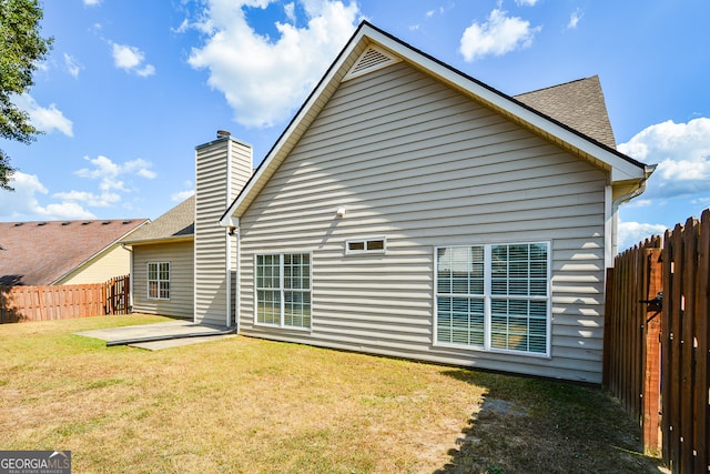 rear view of house featuring a patio area and a lawn