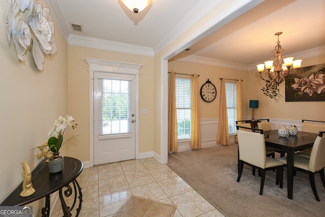 dining area with ornamental molding, light colored carpet, and a chandelier