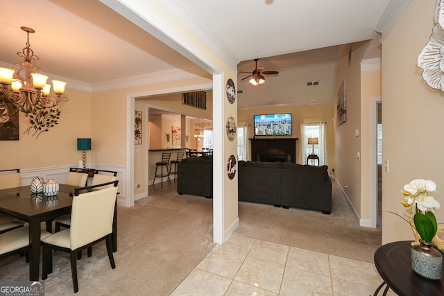 dining room featuring light carpet, ceiling fan with notable chandelier, and crown molding