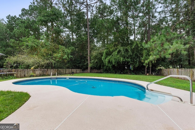 view of swimming pool with a yard