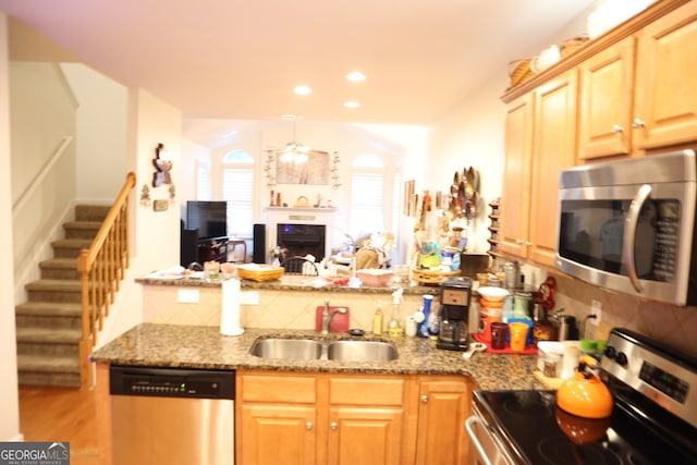 kitchen with light hardwood / wood-style flooring, sink, appliances with stainless steel finishes, and decorative backsplash