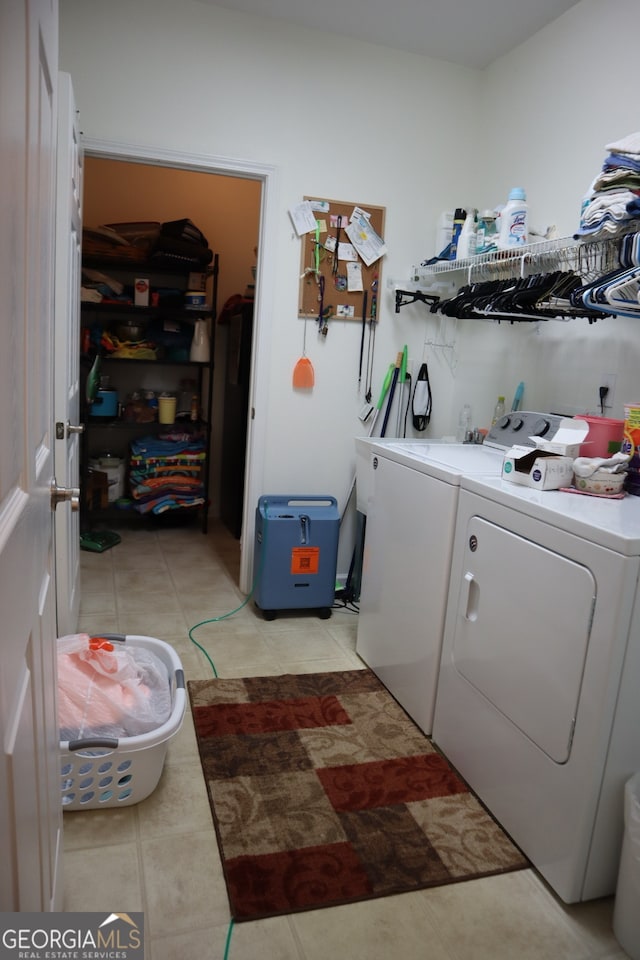 laundry area featuring washer and dryer and light tile patterned floors