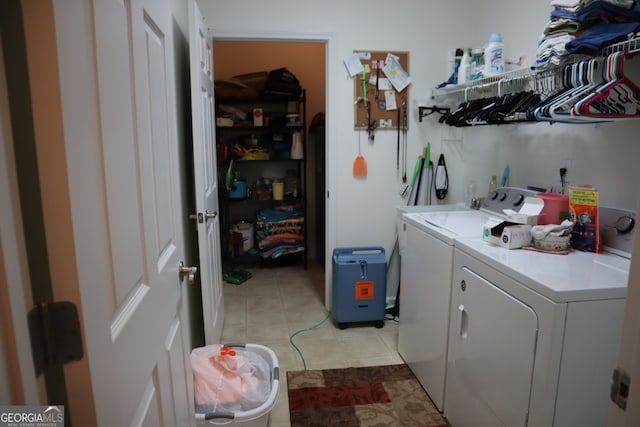 clothes washing area with light tile patterned floors and washer and dryer