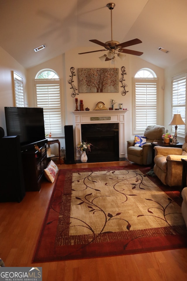 living room with lofted ceiling, hardwood / wood-style floors, and ceiling fan