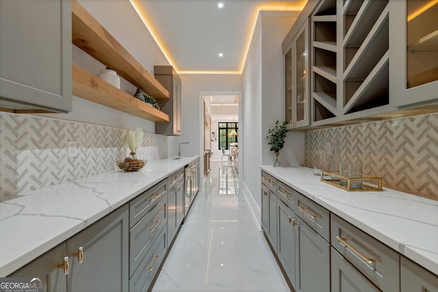 kitchen with gray cabinets, light stone countertops, and decorative backsplash