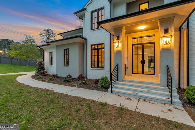 exterior entry at dusk featuring a yard