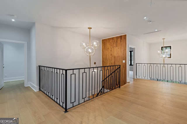 hall with hardwood / wood-style flooring and a chandelier