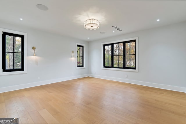 spare room featuring a wealth of natural light and light hardwood / wood-style flooring